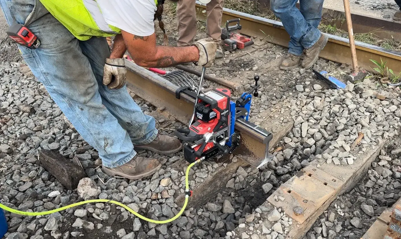 Track crew drilling a rail joint bolt hole using the FTS RailEase battery-powered rail drill
