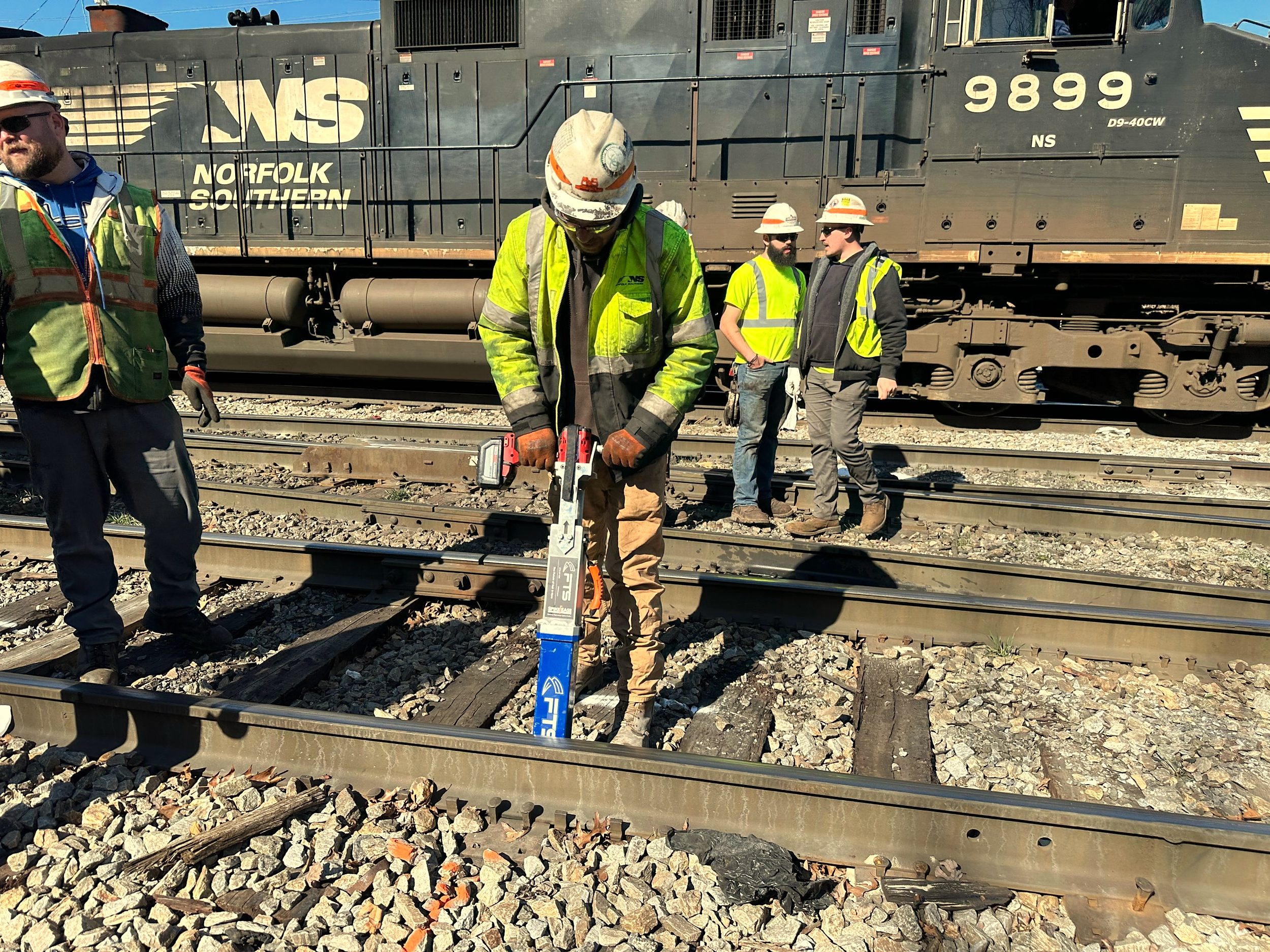 Railroad worker using SpikeEase to remove a track spike